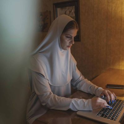 A woman in scarf working on a laptop